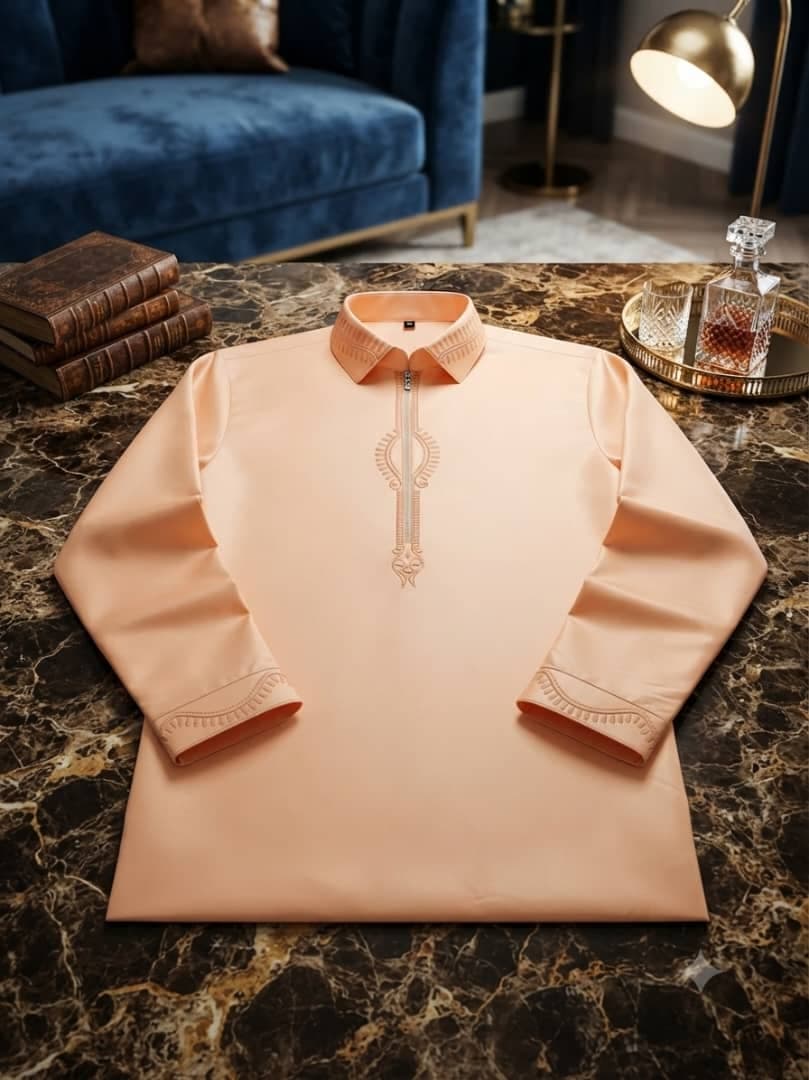 Peach long sleeve jalabia with collar and embroidery on marble table.