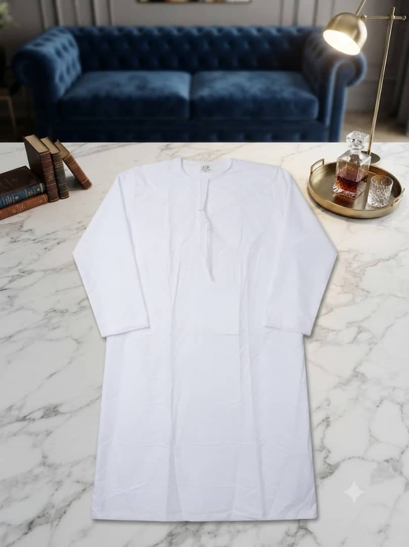 White plain long sleeve jalabia on marble table with books.