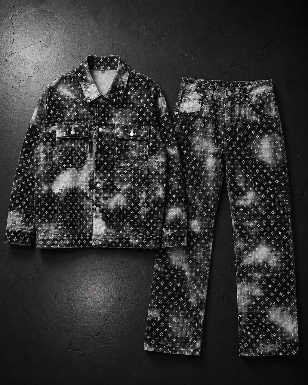 Black and white tie-dye monogram print denim jacket and pants flat lay on dark background.