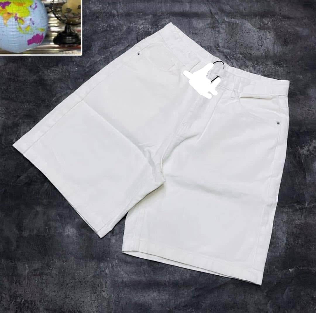 White shorts laid on dark surface with small inset image.