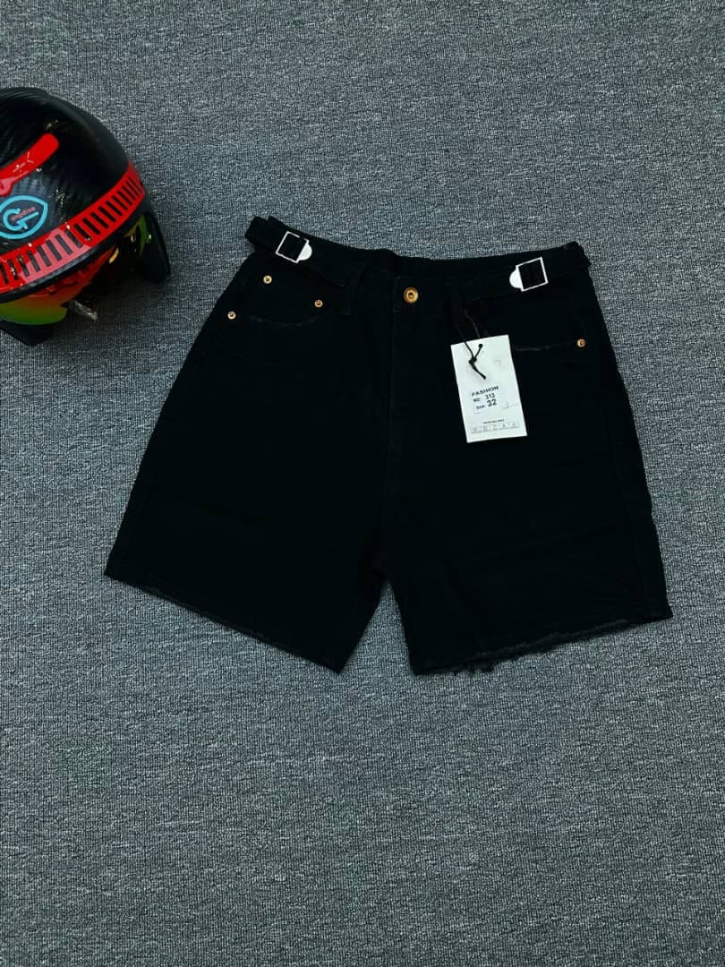 Black denim shorts with double buckle waist straps, gold buttons and attached tag.