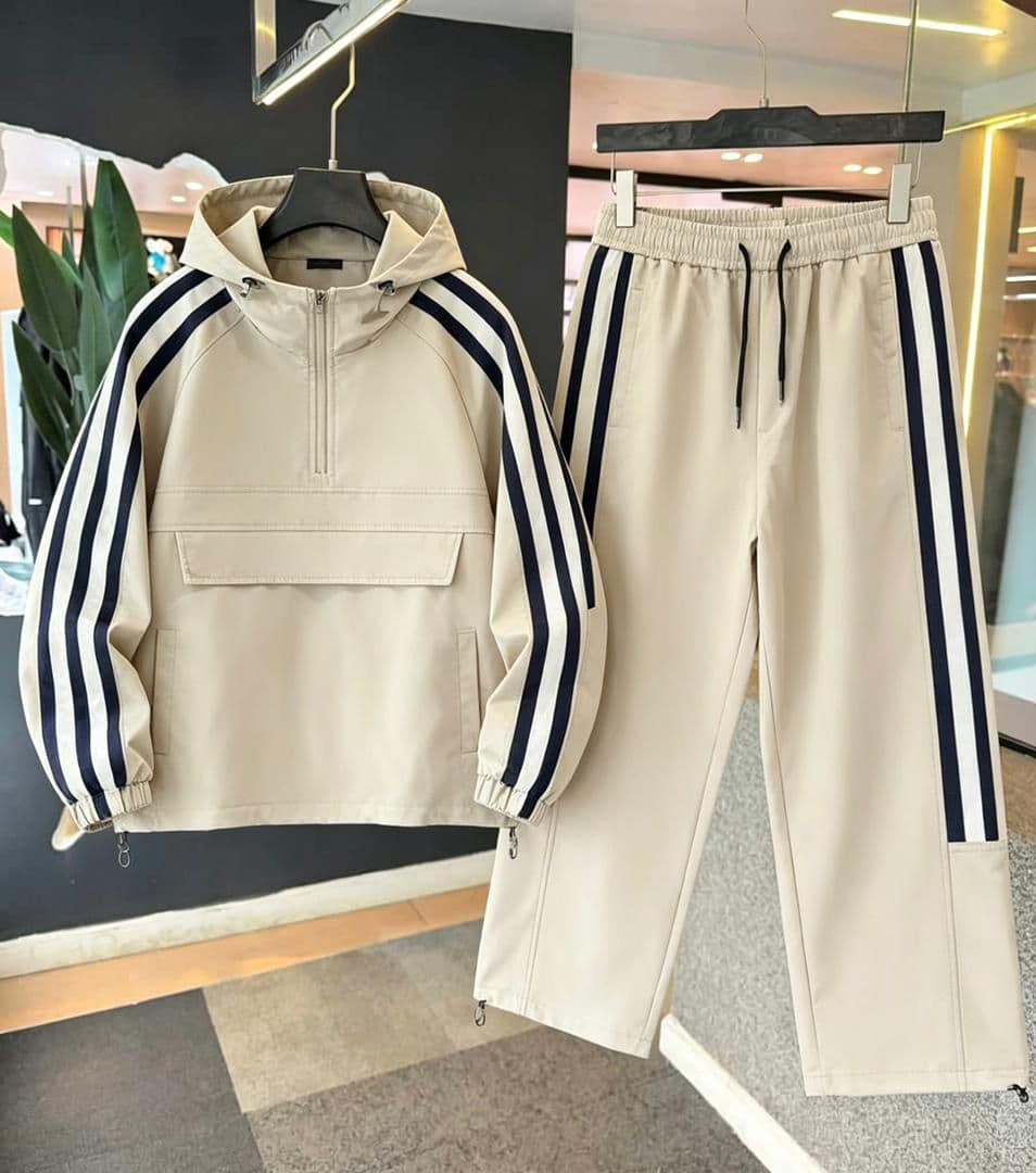 Cream striped hooded cargo tracksuit set with navy accents on jacket sleeves and pants.