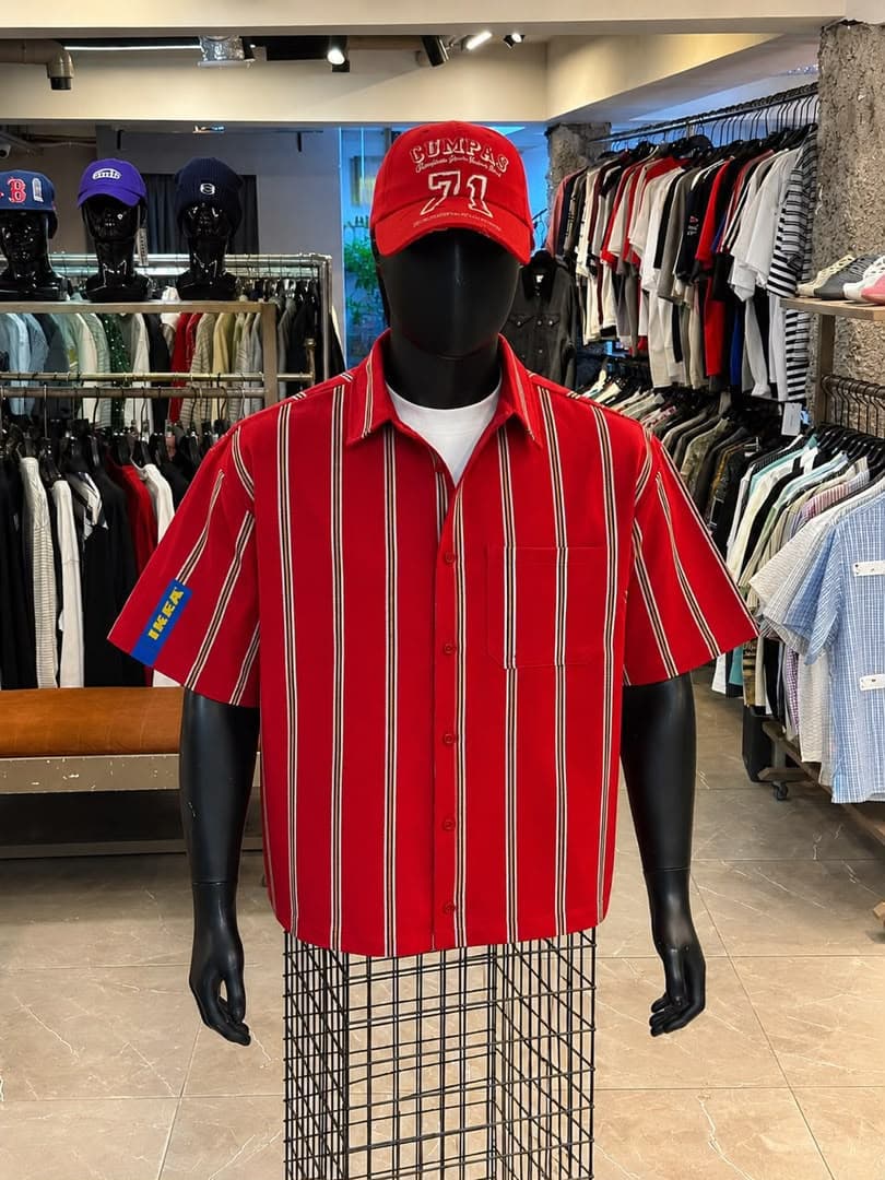 Red striped short sleeve button-up shirt on mannequin with blue sleeve patch.