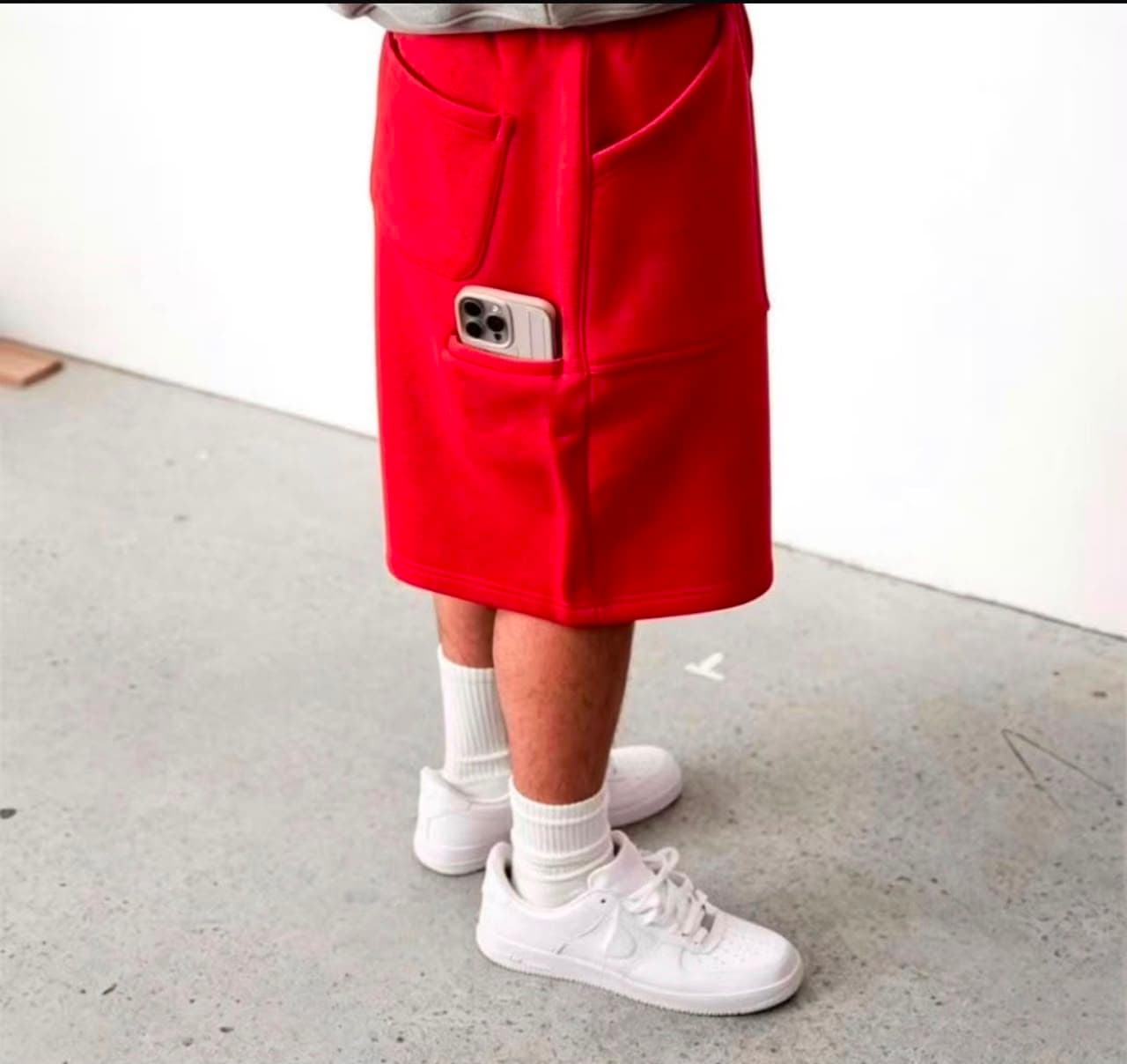 Model wearing red 3/4 fleece shorts with phone in side pocket.
