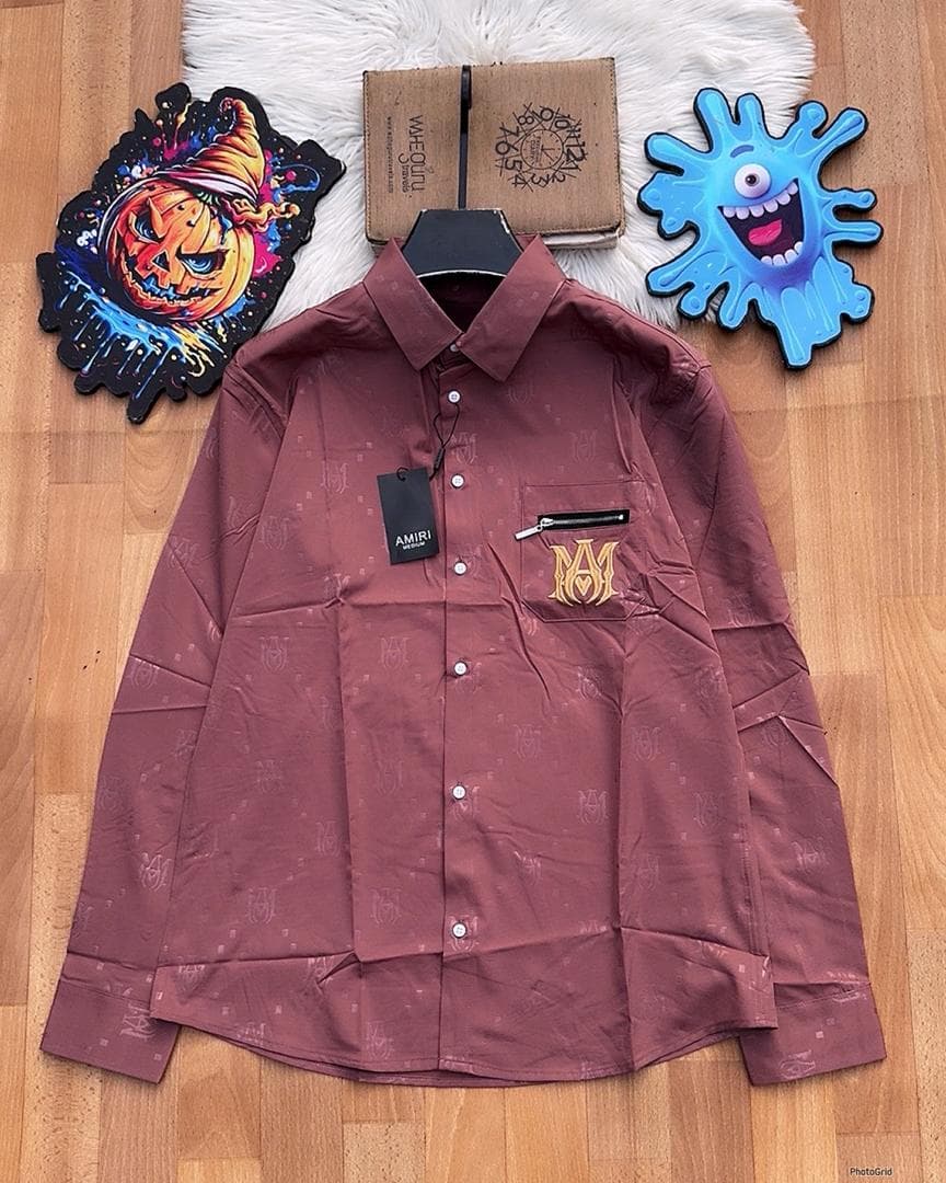 Burgundy Amiri monogram long sleeve shirt with zip pocket laid flat.