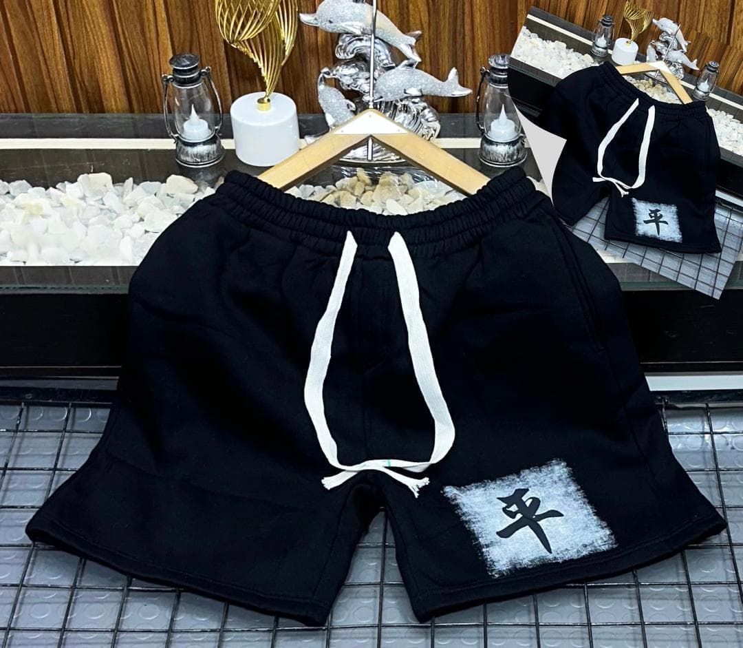 Black fleece shorts with white square character graphic on leg.