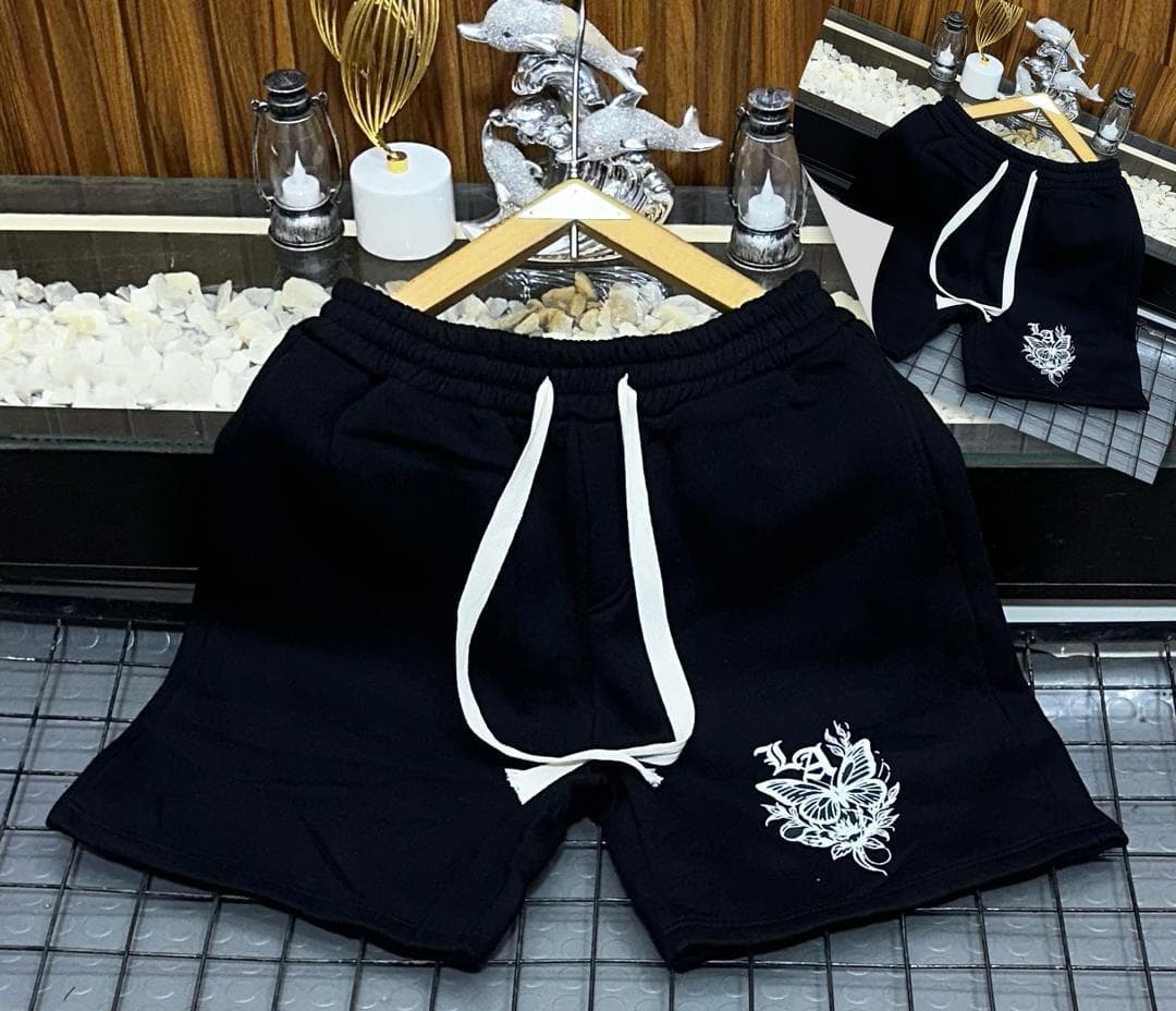 Black fleece shorts with white butterfly and floral embroidery.