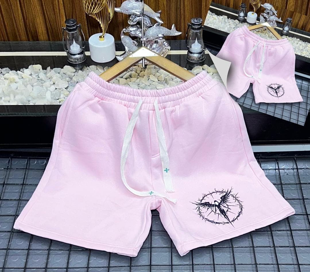 Pink fleece shorts with black thorn bird circular embroidery on leg.