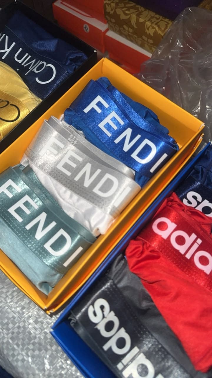 Assorted big band boxer briefs with wide FENDI and adidas waistbands in multiple colors displayed in boxes.