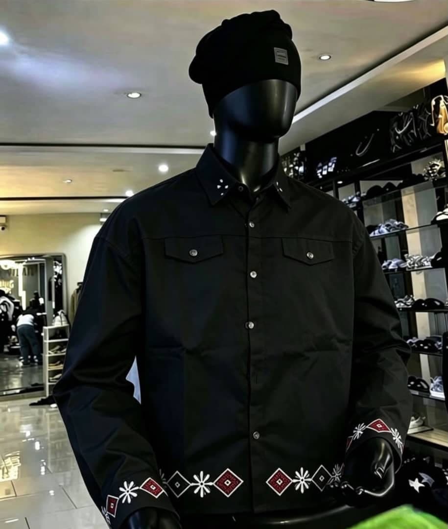 Black long sleeve button-up shirt with embroidery on cuffs and hem, shown on mannequin.