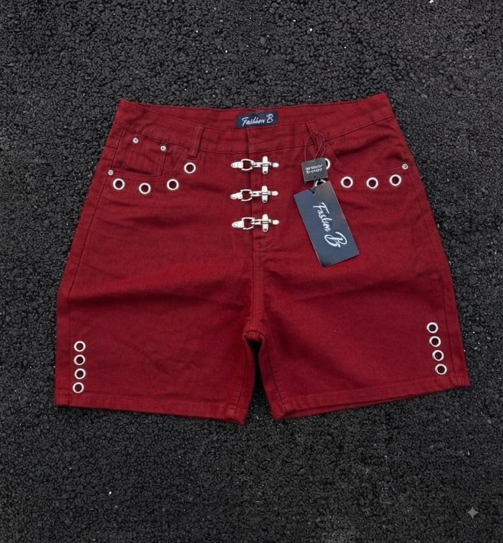 Red denim shorts with buckle closures and grommet details.