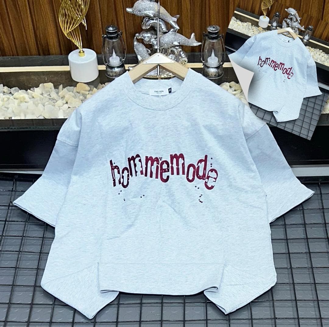 Light gray oversized t-shirt with red Hommemode dripping graphic print, flat lay on grid with hanger and detail inset.