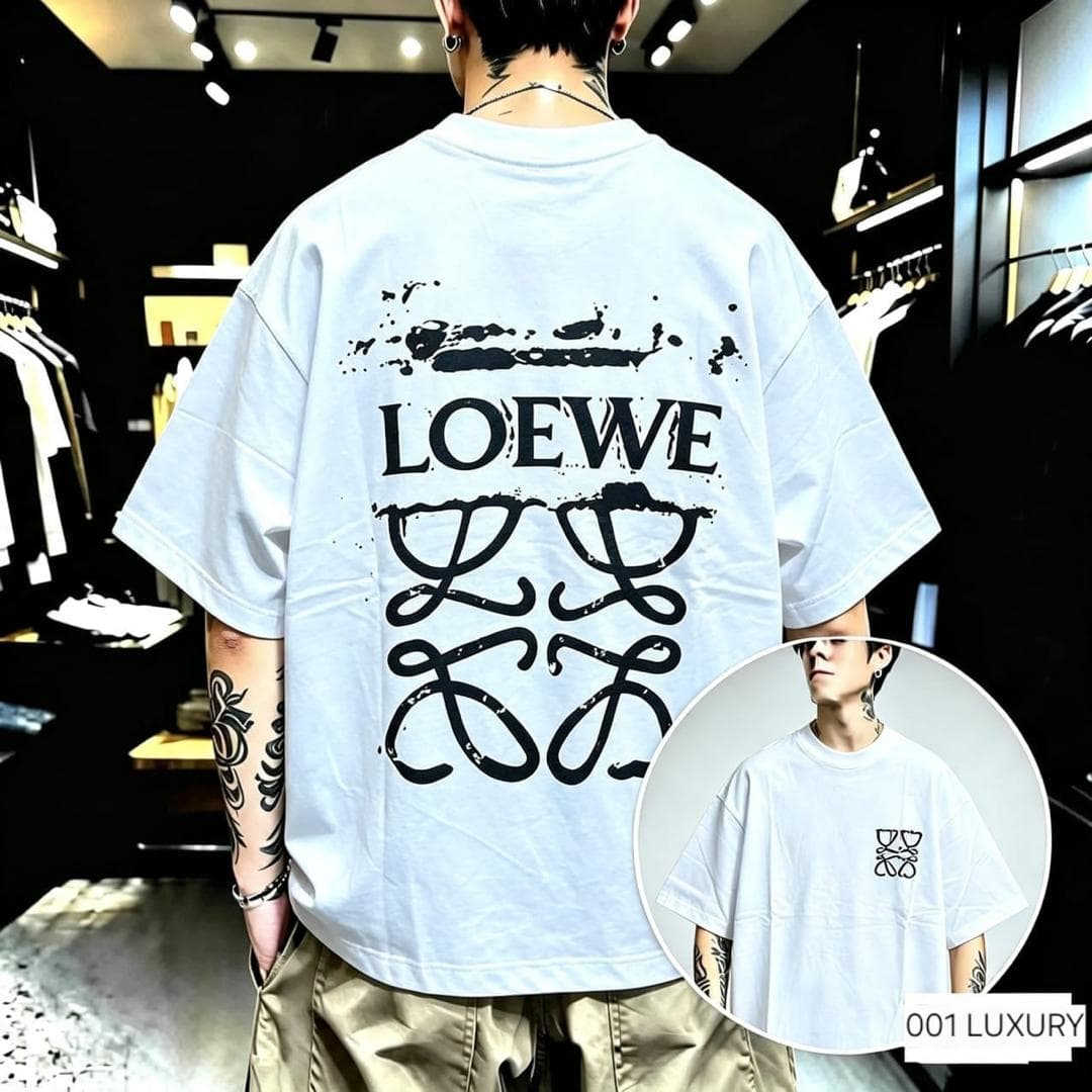 Man from back in white oversized t-shirt with large black Loewe graphic and splatter on back.
