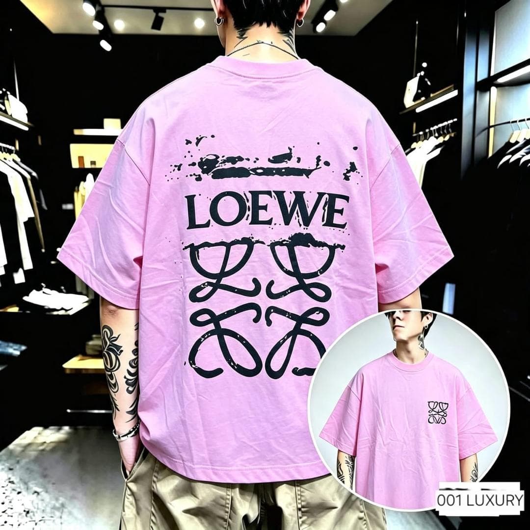 Man from back in pink oversized t-shirt with large black Loewe graphic and splatter on back.