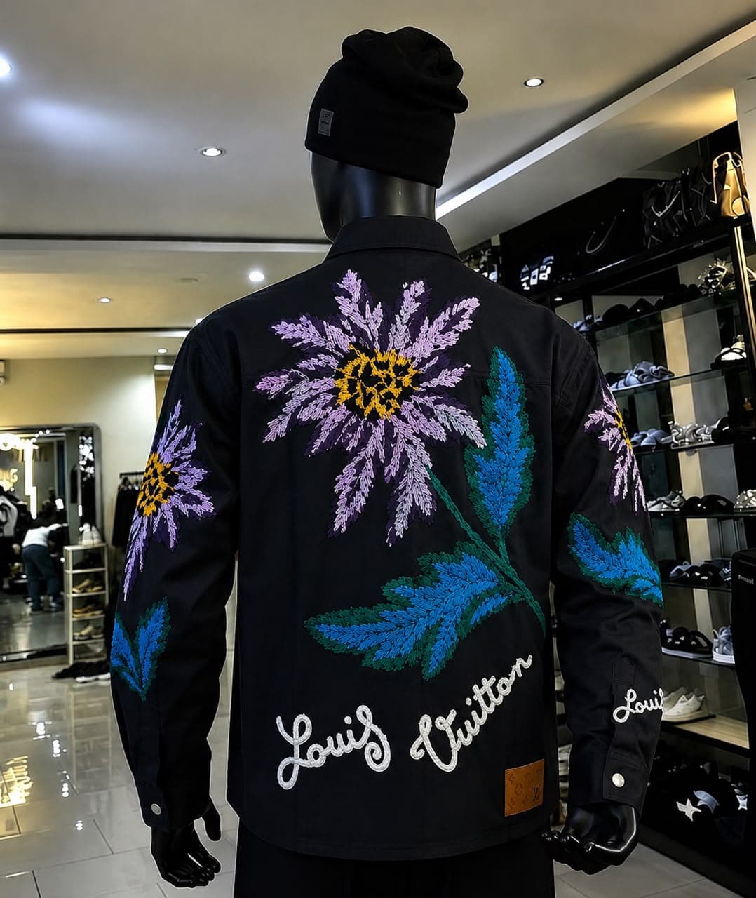 Black floral embroidered jacket on mannequin, back view.