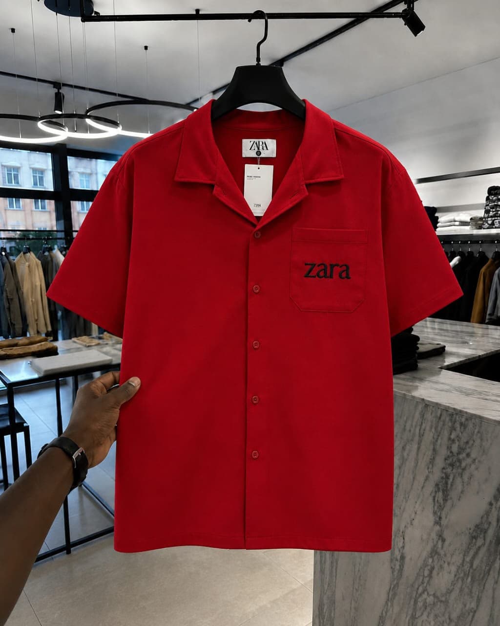 Red short-sleeve button-up shirt with black 'zara' embroidery on chest pocket.