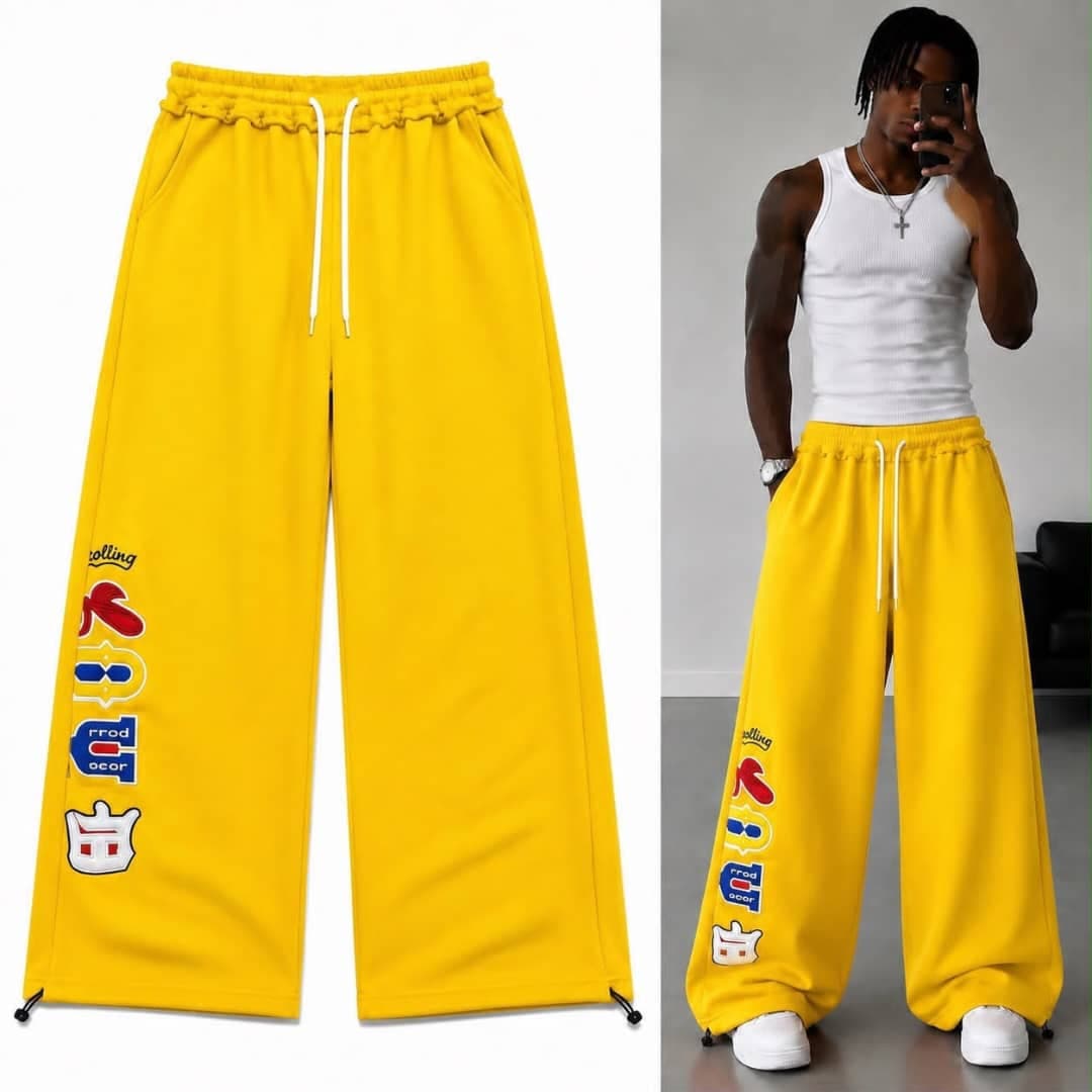 Yellow wide-leg joggers with colorful side graphic and crown detail, flat lay and model views.