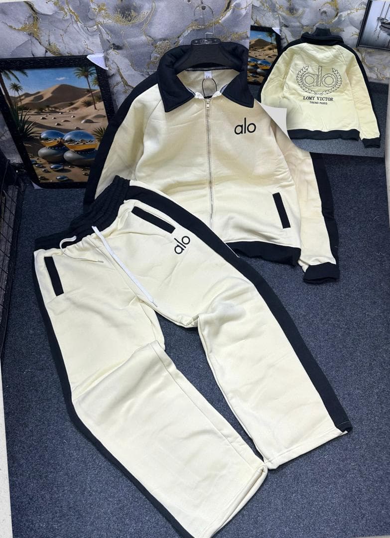 Cream and black Alo tracksuit set with zip jacket and pants.