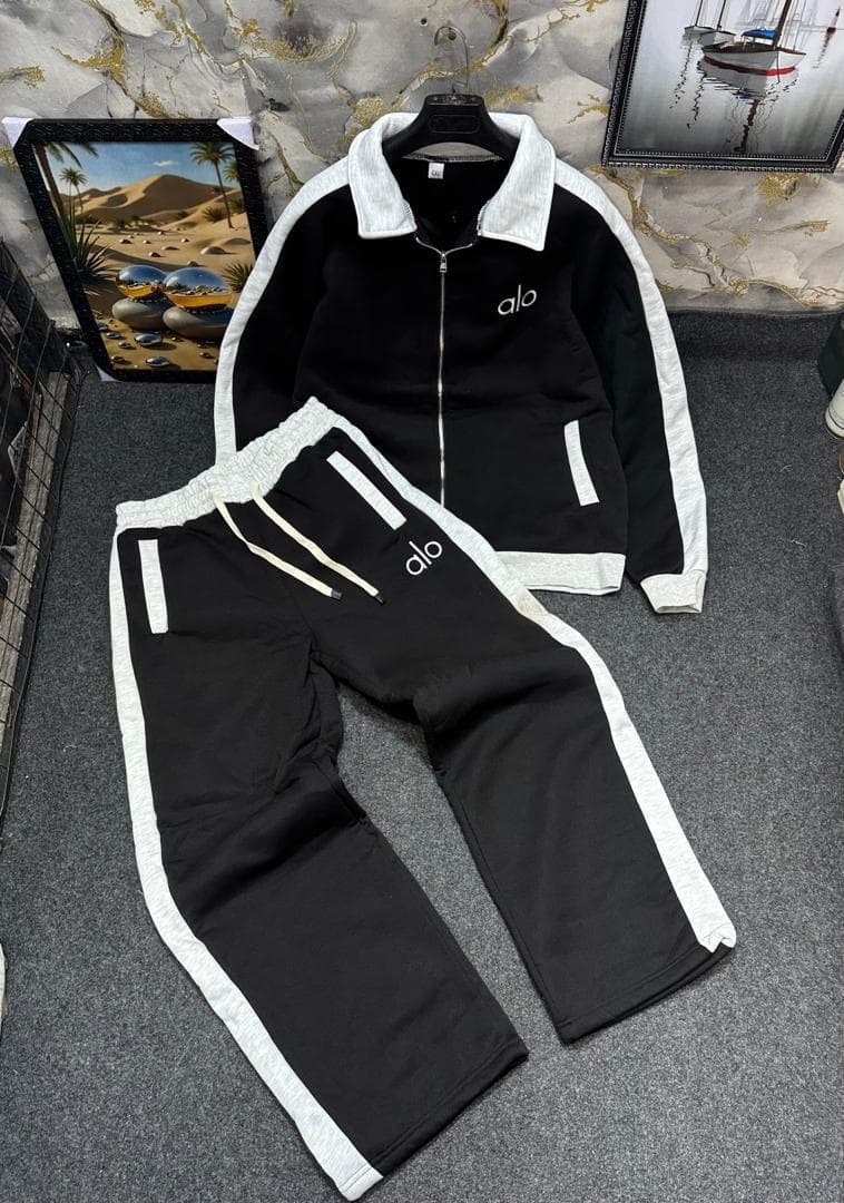 Black and white Alo tracksuit set with zip jacket and pants.