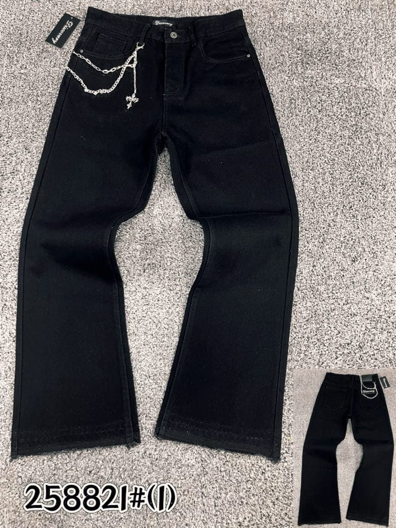 Black baggy jeans with silver chain and cross pendant attached at the waist, flat lay view.