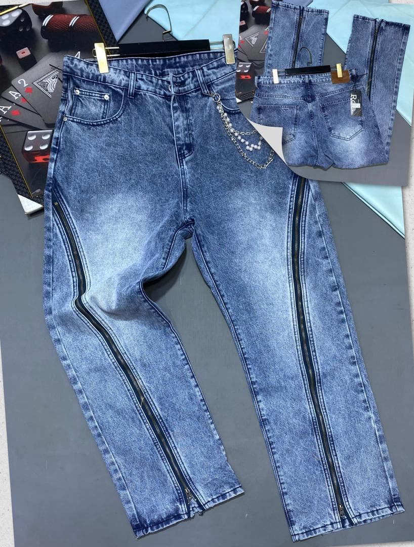 Blue jeans with side zippers, chain detail and inset views of back pockets.