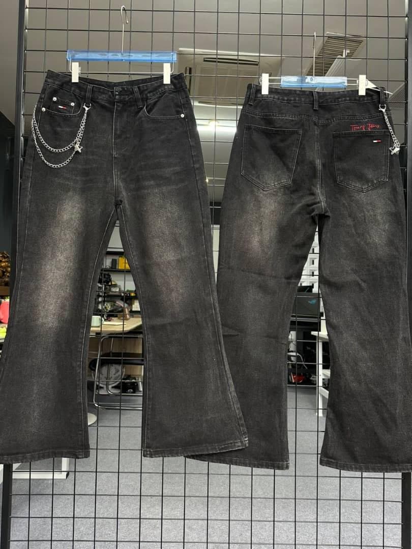 Front and back of black flared jeans with chain on back pocket hanging on grid.