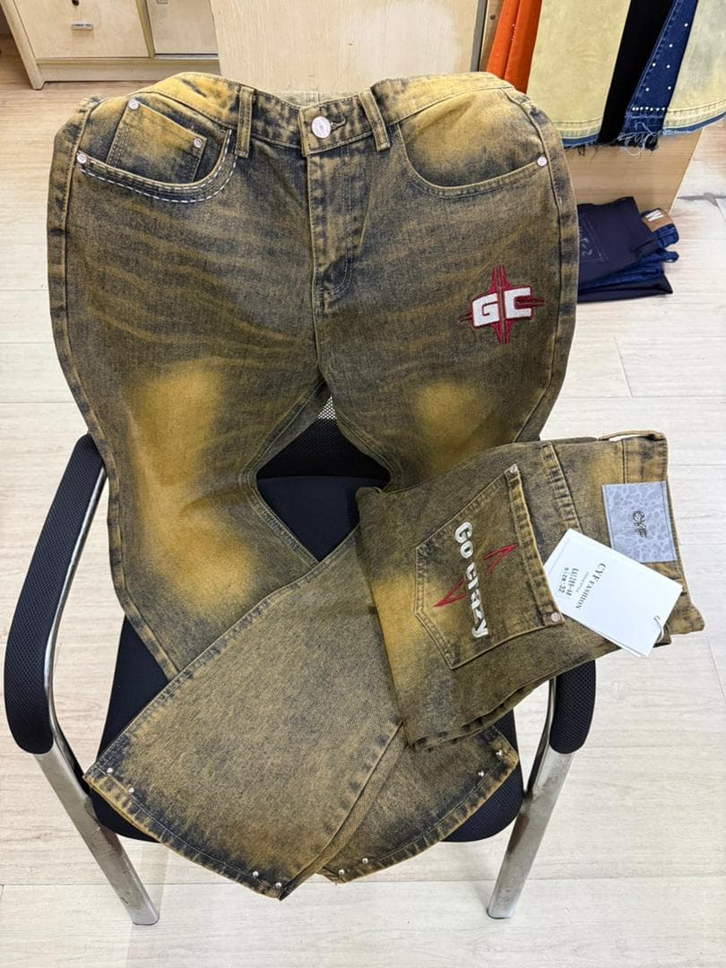 Yellow faded jeans with GC logo on chair and folded back pocket showing Go Crazy text.