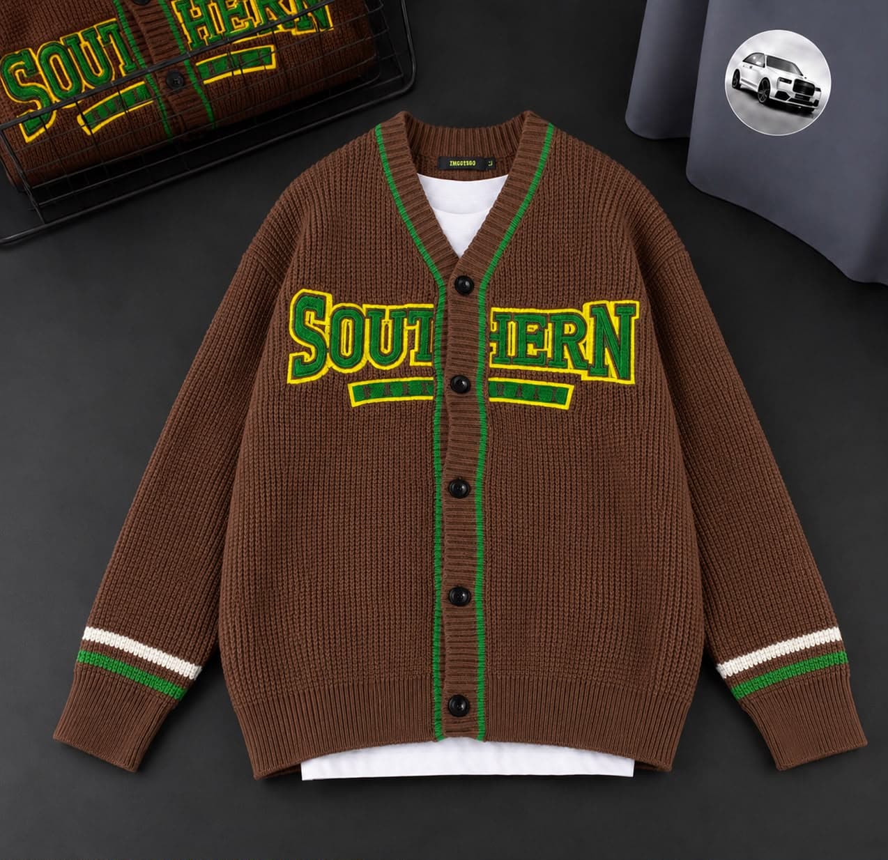 Brown Southern cardigan with colorful embroidery and green trim laid flat.