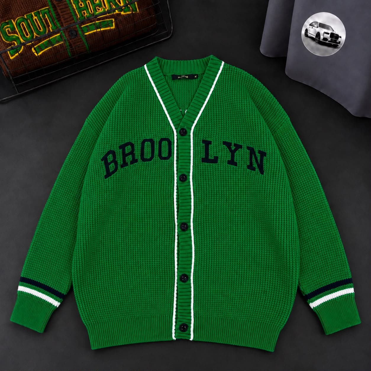 Green Brooklyn cardigan with white and navy striped cuffs.