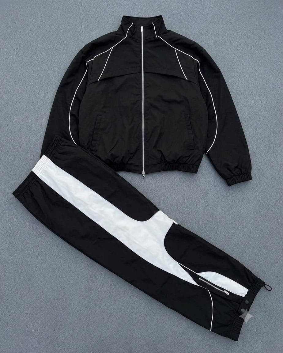 Black cargo tracksuit with white contrast stripes and panels, flat lay view.