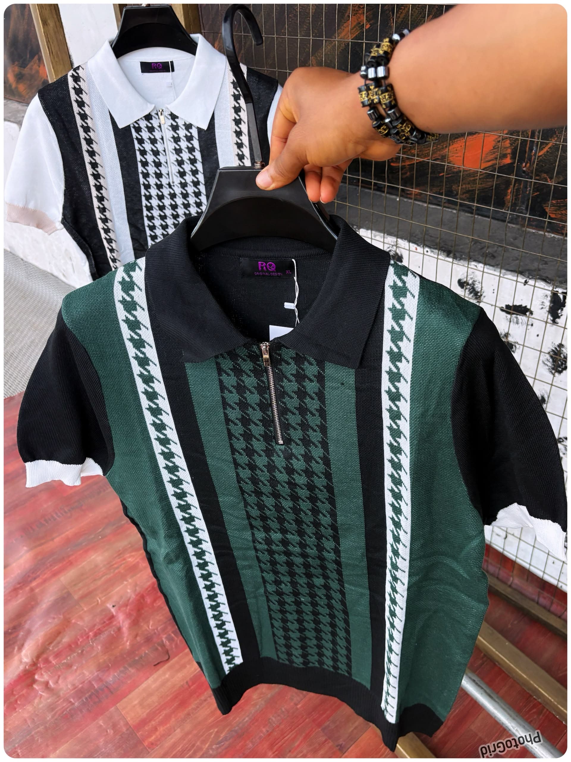 Black and green houndstooth knit polo held in front with white and black version in background.