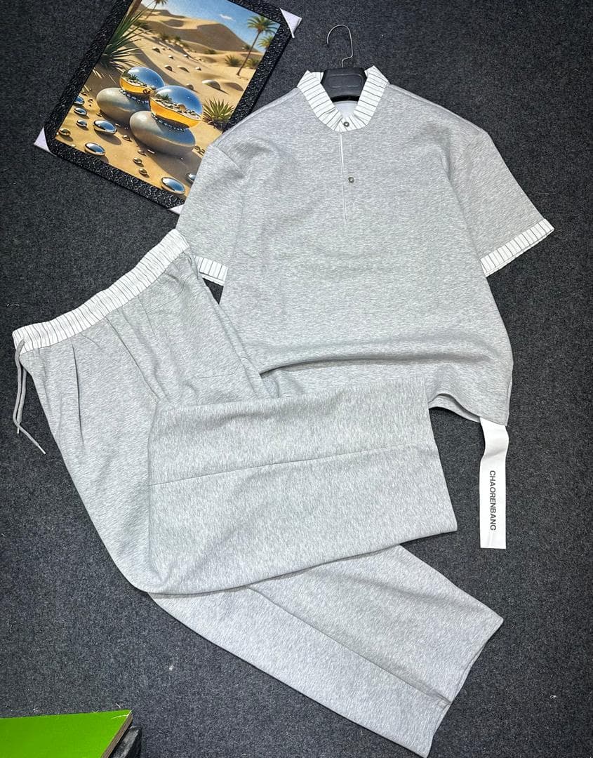 Gray two-piece set with striped trim on short-sleeve top and drawstring pants.