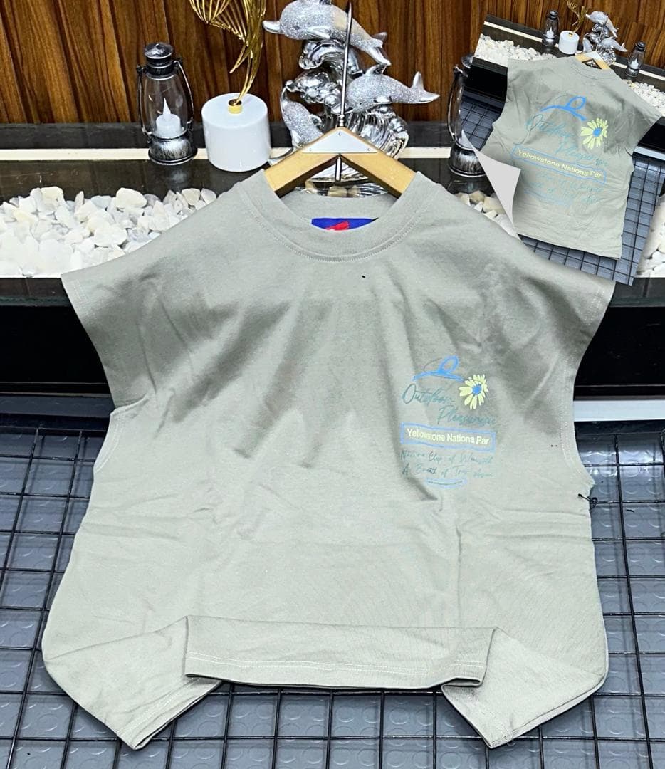 Olive sleeveless top with Outdoor Pleasure print on hanger.