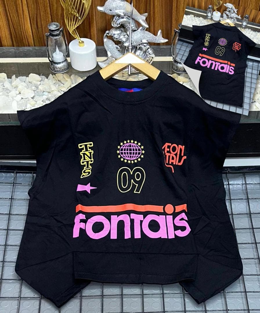 Black sleeveless top with Fontais graphic print on hanger.