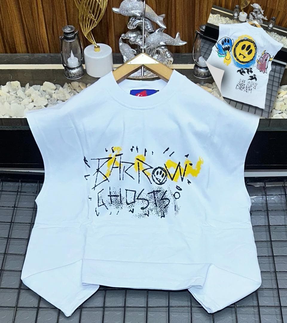 White oversized sleeveless top with black and yellow graffiti print on chest.