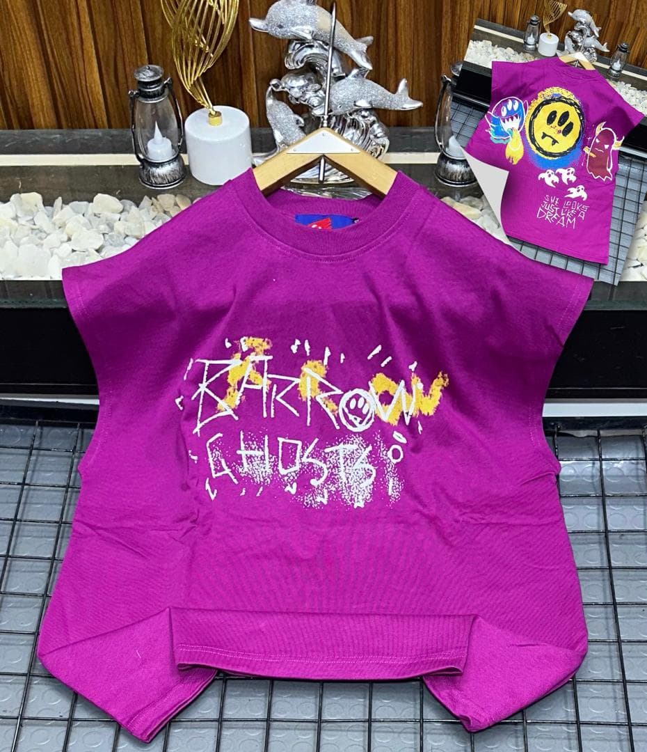 Purple oversized sleeveless top with yellow and white graffiti print on chest.