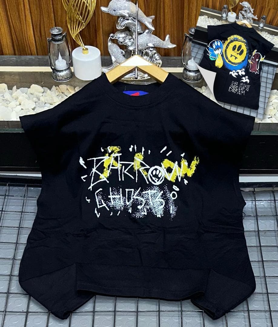 Black oversized sleeveless top with yellow and white graffiti print on chest.