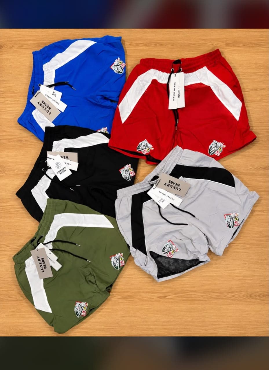 Assorted colorways of stripe panel cargo shorts arranged on wooden background.