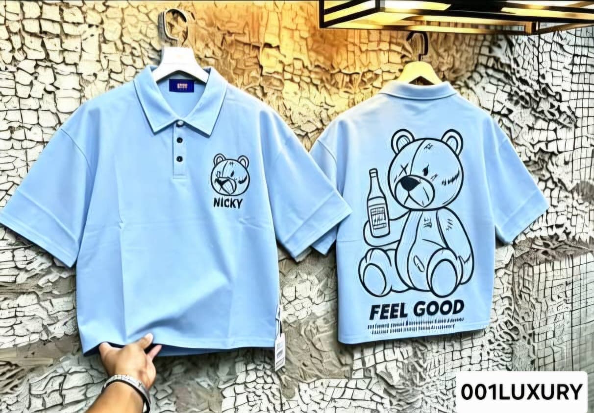 Front and back of light blue polo shirt with teddy bear graphics, NICKY text and FEEL GOOD slogan.
