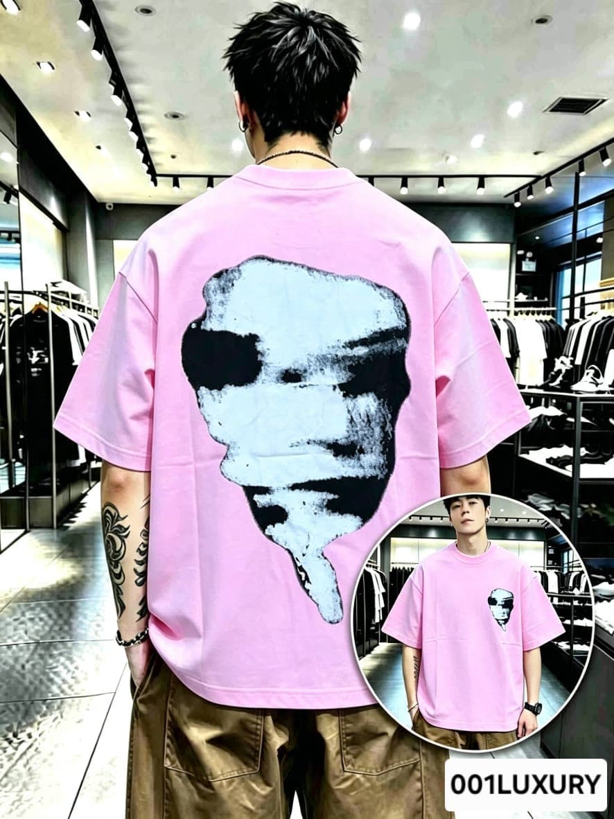 Man viewed from back wearing pink oversized t-shirt with large abstract face graphic print.