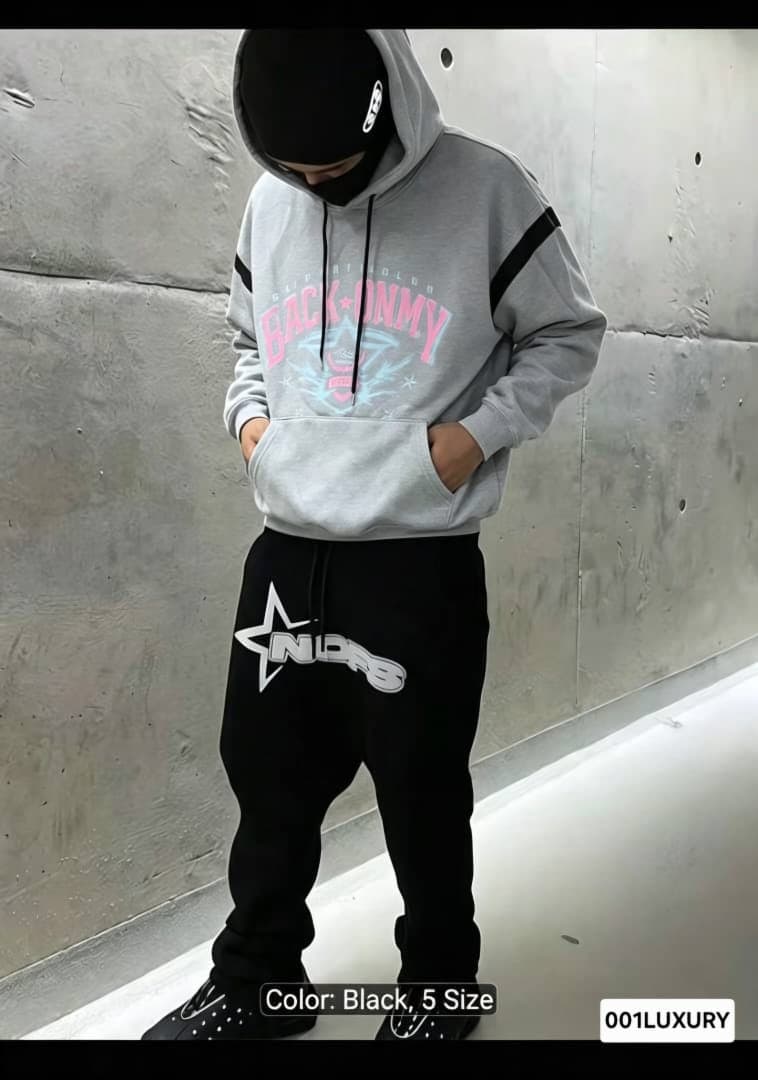 Man in gray Back Onmy hoodie and black pants with star logo, full body shot.