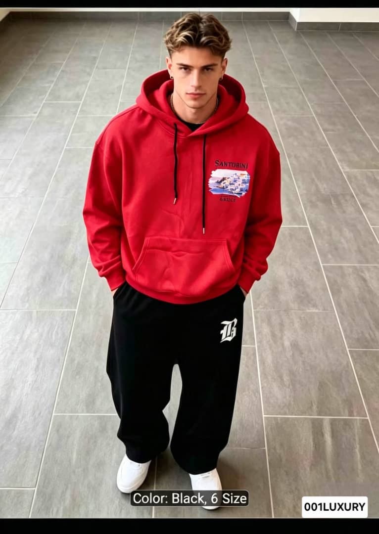 Man in red Santorini graphic hoodie standing with hands in pockets.