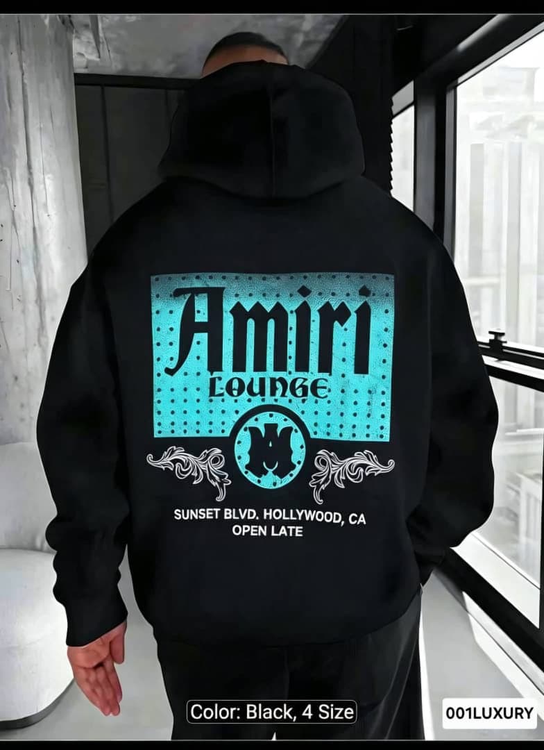 Man in black Amiri Lounge hoodie showing full back graphic with turquoise print.