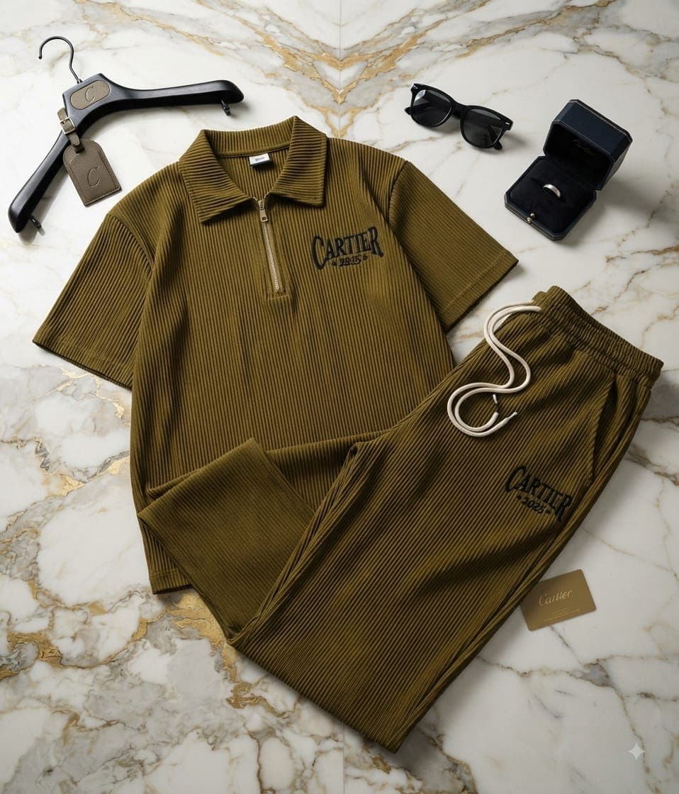 Olive green ribbed quarter-zip polo top and joggers with Cartier embroidery on marble floor.