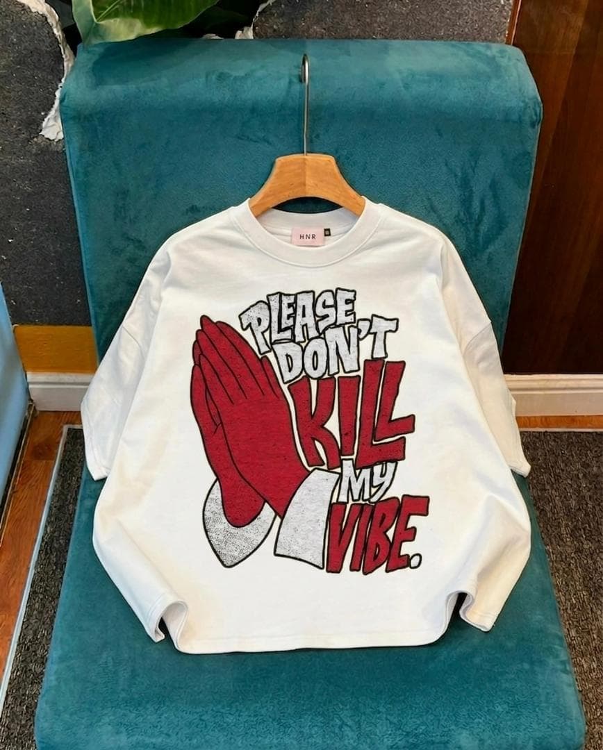 White oversized long sleeve crop tee with red praying hands and Please Don't Kill My Vibe text.