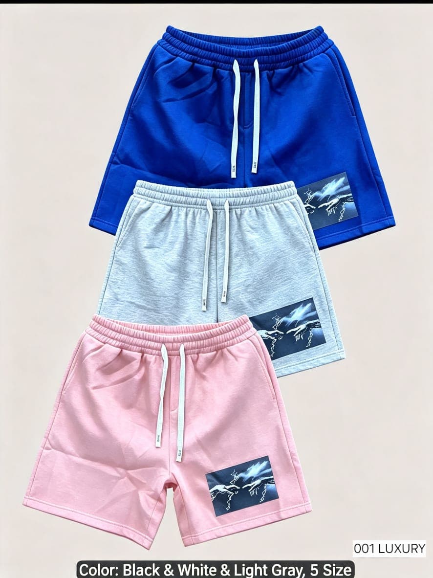 Blue, light gray and pink shorts with hand and lightning graphic print shown stacked.