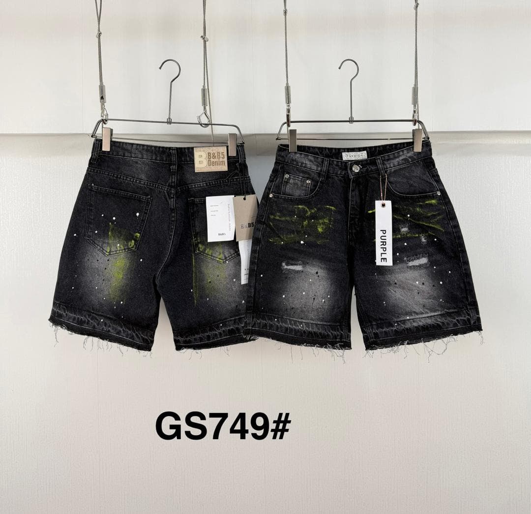 Black denim shorts with green paint splatter shown hanging side by side.