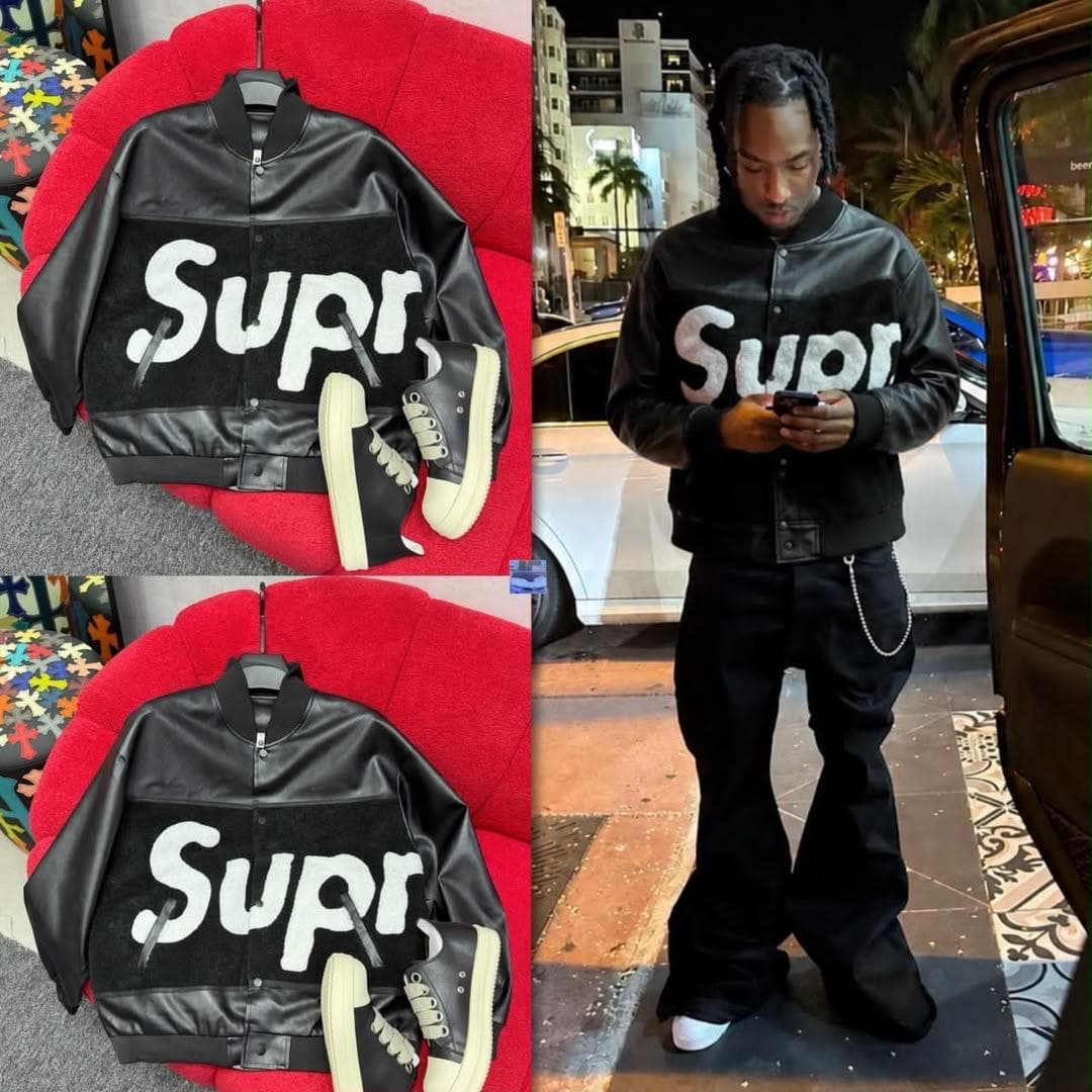Black Supr varsity bomber jacket shown flat with black sneakers and modeled at night outdoors.