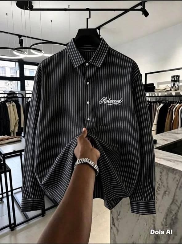 Black striped button-down shirt held up showing relaxed fit and white chest embroidery.
