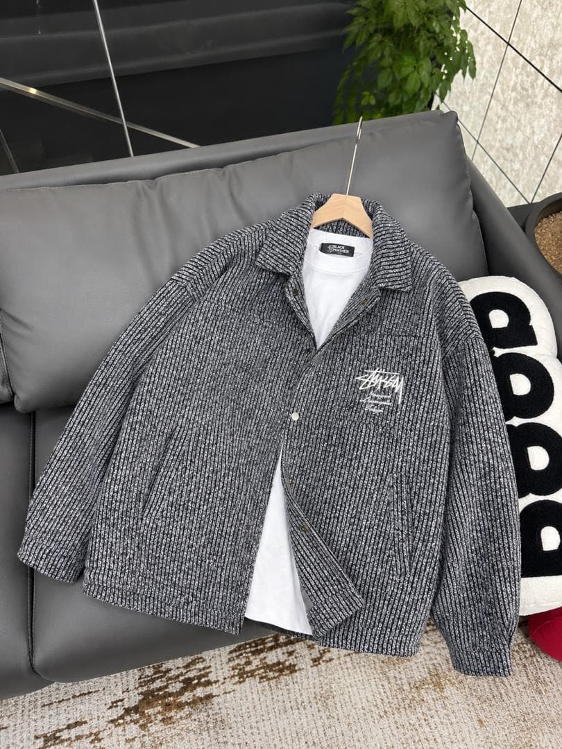 Grey ribbed knit jacket with Stussy logo on chest, layered over white t-shirt.